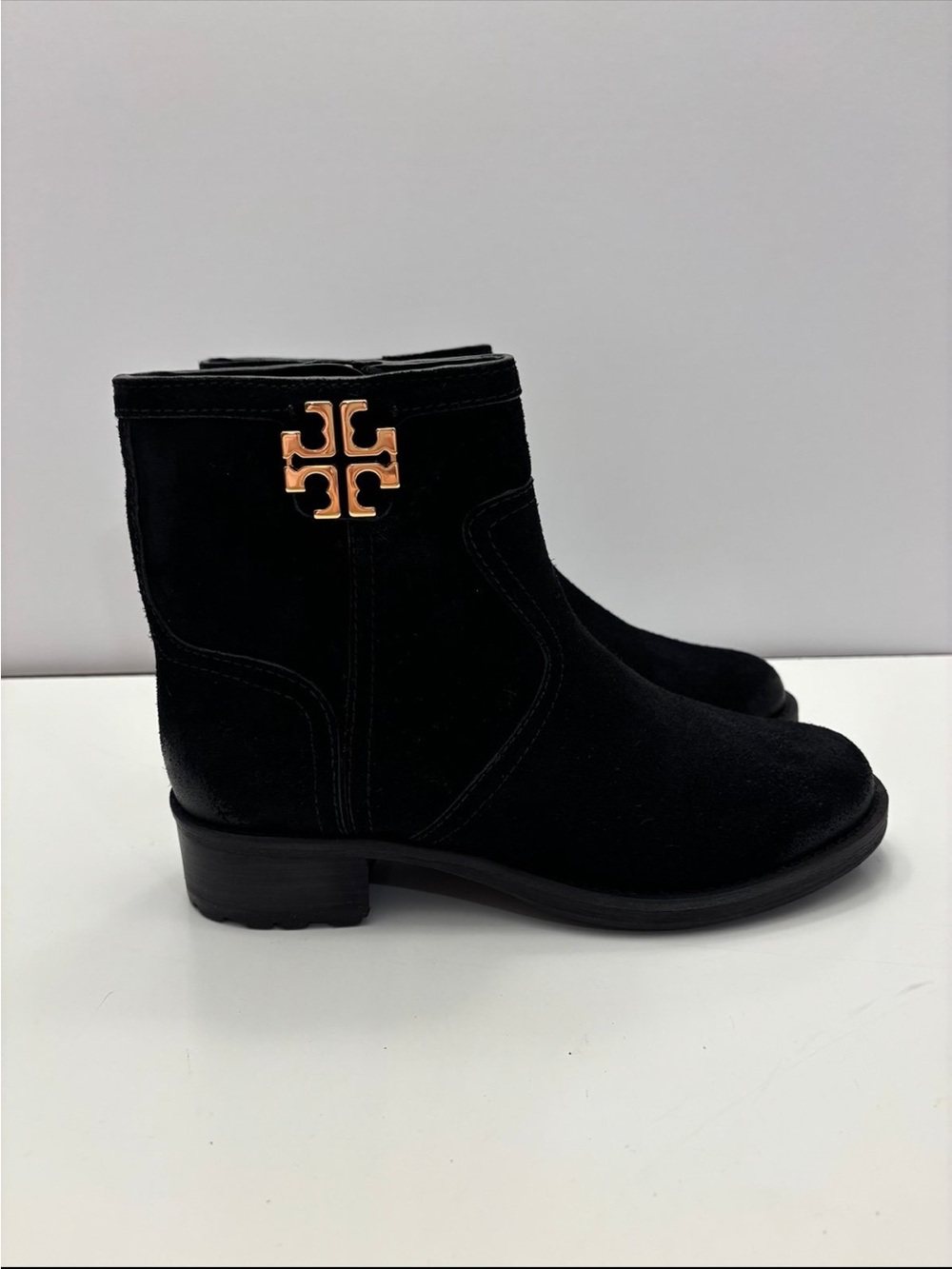Tory Burch black suede Eloise flat booties with a prominent gold-tone metal logo